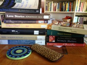 At the writer's desk, with a pile of books on LGBT History