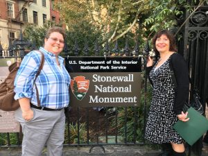 Susan and her colleague standing next to an NPS sign that says "Stonewall National Monument"