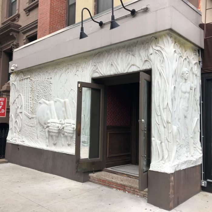 A white bas relief building mural